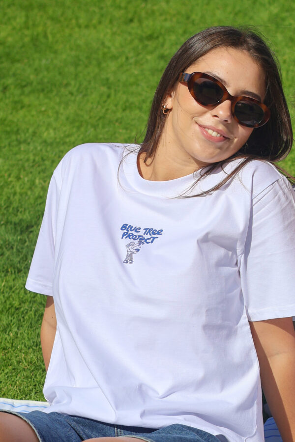 White women’s t-shirt with a blue graphic of a lady painting, supporting mental health awareness through Blue Tree Project charity