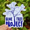Blue Tree Project logo sticker featuring a stylised blue tree with delicate, sparse branches, alongside bold, uppercase 'Blue Tree Project' text in a friendly, modern font. Printed on a white background, the sticker is available in a single size and offered in packs of 1, 5, 10, 20, 30, or 50.